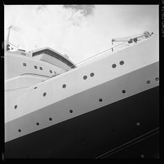 a large cruise ship is docked at the dock with it's mast in the foreground