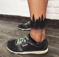 a person with black and green tattoos on their legs