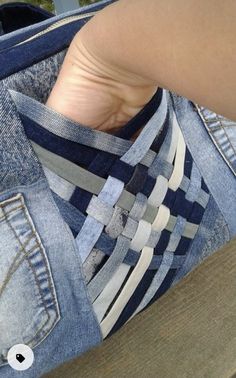 a person's foot sticking out of a pair of blue jean pants with white and grey stripes