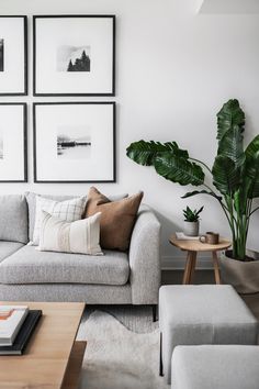 a living room filled with furniture and framed pictures on the wall above it's coffee table