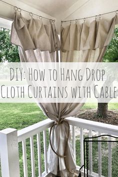 a diy farmhouse house drop cloth curtains on a porch with text overlay that reads diy farmhousehouse drop cloth curtains