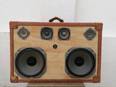 an old fashioned wooden box with speakers on it's sides and leather strap around the edges