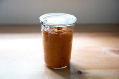 a glass jar filled with food sitting on top of a wooden table