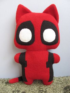 a red and black stuffed animal with big eyes