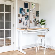 a room with a desk, chair and pictures on the wall