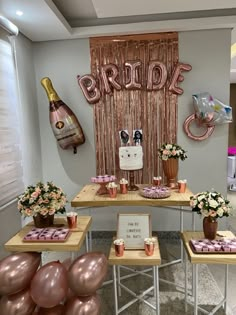 the table is set up for a bridal party with pink balloons and champagne bottles