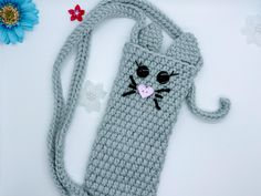 a crocheted bag with a cat on the front and a flower in the back