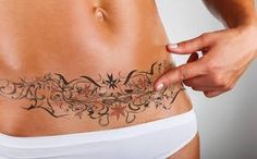 a woman's stomach with an intricate tattoo design on the side, and her right arm