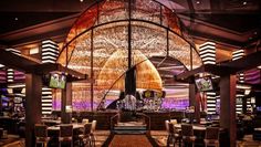 the inside of a restaurant with lots of tables and chairs in front of a large chandelier