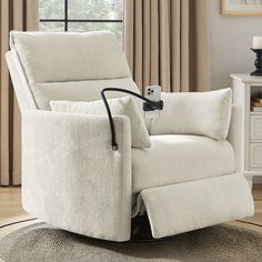 a white recliner chair sitting on top of a rug in front of a window