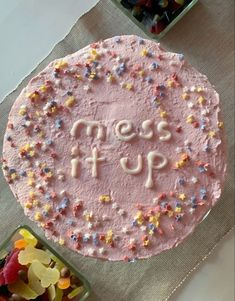 a pink frosted cake sitting on top of a table