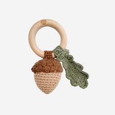 a crocheted wooden toy with an acorn and leaf decoration