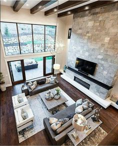 an aerial view of a living room with couches, coffee table and fireplace in the center