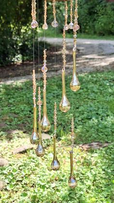 a wind chime hanging from a tree in the grass