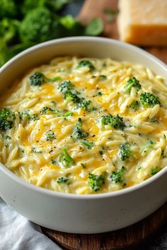 a white bowl filled with pasta and broccoli on top of a wooden cutting board