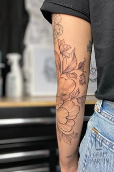 Shows a black linework tattoo of a large peony flower and leaves on a mid arm, which bends with the elbow. Fineline Forearm Sleeve, Floral Sleeve Add On Tattoo, Sleeve Color Tattoos For Women, Peony Arm Sleeve, Japanese Floral Sleeve, Inner Arm Tattoo Sleeve, Fine Line Half Sleeve Tattoo, Floral Sleeve Tattoo Black And White, Upper Half Sleeve Tattoo For Women