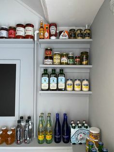 an assortment of condiments on shelves in a kitchen