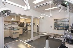 an operating room with multiple lights and equipment in it's center, as seen from the doorway