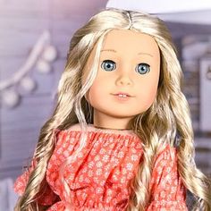 a doll with long blonde hair and blue eyes wearing a red dress in a kitchen