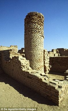 an old brick structure in the desert with no people around it and blue sky above