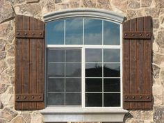 a window with wooden shutters on a stone building