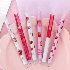 four pens sitting on top of a pink plate