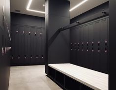 an empty room with rows of lockers in the center and pink lights on the ceiling