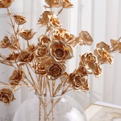 a vase filled with gold colored flowers on top of a table