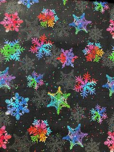 a black background with multicolored snowflakes all over the place and on it