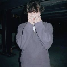 a young man covers his face with his hands