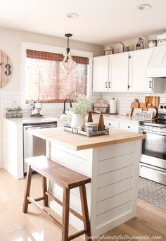 a kitchen with white cabinets and wooden stools