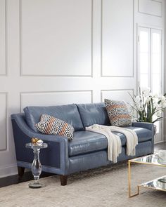 a living room with white walls and blue leather furniture