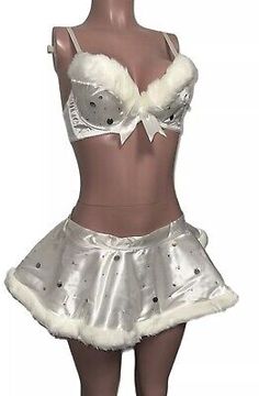 a female mannequin wearing a silver skirt and white bra with fur trims