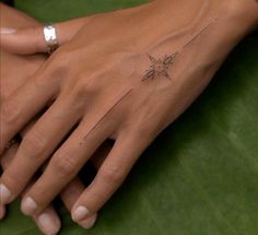 a woman's hand with a small tattoo on it