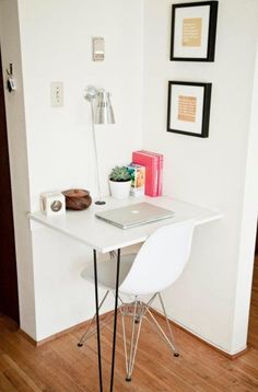 a white desk with a laptop on it in a small room next to a wall