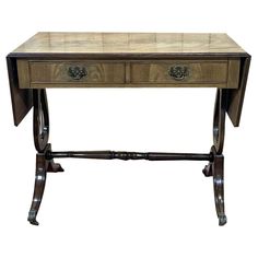 a wooden table with two drawers on one side and an ornate design on the other