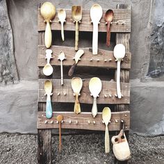 spoons and spatulas are arranged on an old wooden pallet with hooks