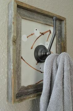 a towel is hanging on the wall next to an old frame with some branches in it