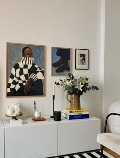 a living room filled with furniture and pictures on the wall next to a white chair