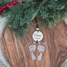 a wooden ornament with baby's feet on it and the name meme