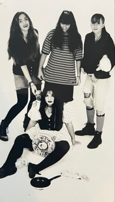 four young women posing for a photo in front of a white background with scissors and hairdryers