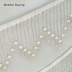 white beaded curtain with pearls hanging from it's side and the words modest saying