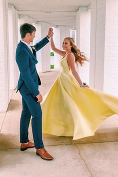 a woman in a yellow dress and a man in a blue suit are dancing together