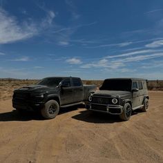 two trucks parked in the middle of a desert