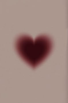 a heart shaped object is shown in the middle of a blurry photo with red light