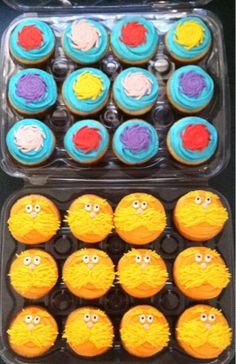 two plastic trays filled with cupcakes covered in frosting and decorated like faces