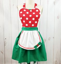 a green and red polka dot apron on a mannequin stand with white dots