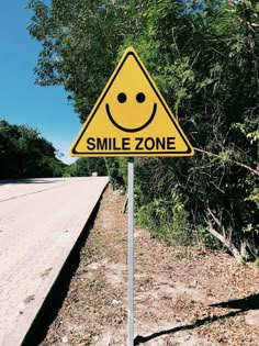 a smile zone sign sitting on the side of a road