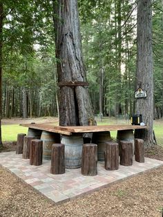 a picnic table made out of old barrels in the middle of a park with trees