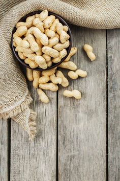 peanuts in a bowl on a wooden table